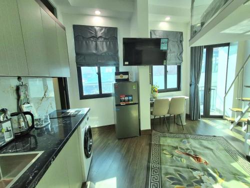 uma cozinha com geladeira e uma mesa com cadeiras em Home 24 12 Đào Tấn em Hanói