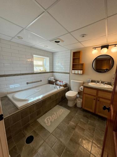 un baño con bañera, inodoro y lavabo en Leinster Loft, en Saint John