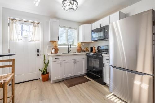 a kitchen with white cabinets and a refrigerator at Casita Calma Guesthouse Mins to DT & Airport in Phoenix