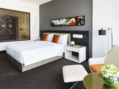 a bedroom with a large white bed and a table at Fairmont Riyadh in Riyadh
