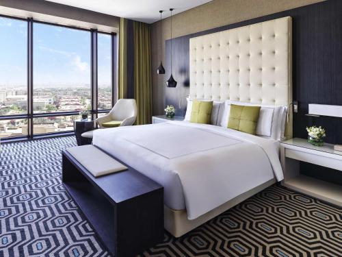 a bedroom with a large bed and a large window at Fairmont Riyadh in Riyadh