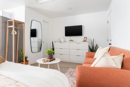 a living room with a couch and a tv at Casita Calma Guesthouse Mins to DT & Airport in Phoenix
