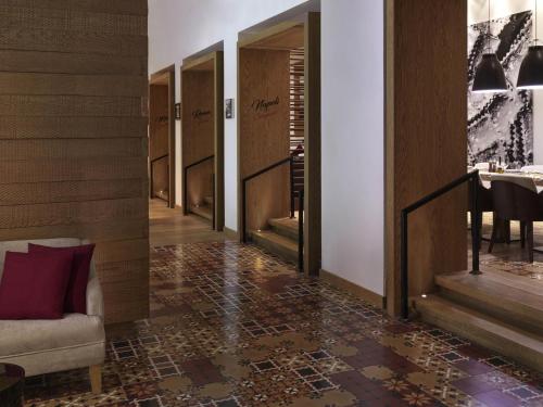 a hallway with a staircase with a chair and a table at Fairmont Riyadh in Riyadh
