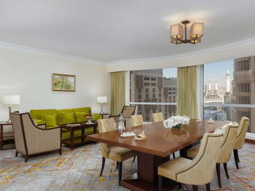 a dining room with a table and a large window at Swissotel Al Maqam Makkah in Makkah