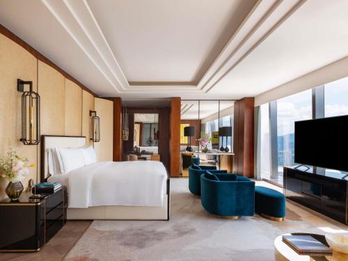 a hotel room with a bed and a television at Raffles Shenzhen, Situated in the heart of One Shenzhen Bay, Book Now to Enjoy Free Minibar and Happy Hour Privileges at Long Bar on 71F in Shenzhen