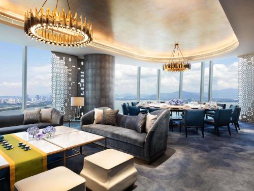 a dining room with tables and chairs and windows at Raffles Shenzhen, Situated in the heart of One Shenzhen Bay, Book Now to Enjoy Free Minibar and Happy Hour Privileges at Long Bar on 71F in Shenzhen