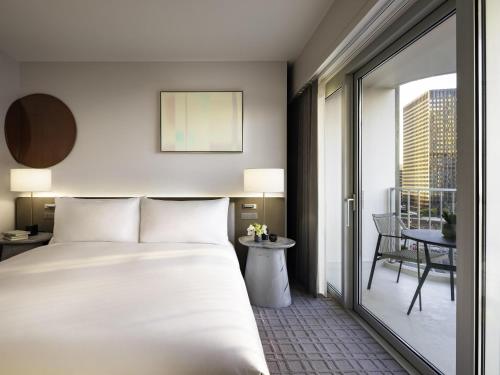 a hotel room with a bed and a balcony at Fairmont Century Plaza Los Angeles at Beverly Hills in Los Angeles