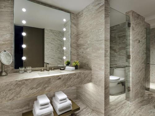 a bathroom with a sink and a toilet and a mirror at Fairmont Century Plaza Los Angeles at Beverly Hills in Los Angeles