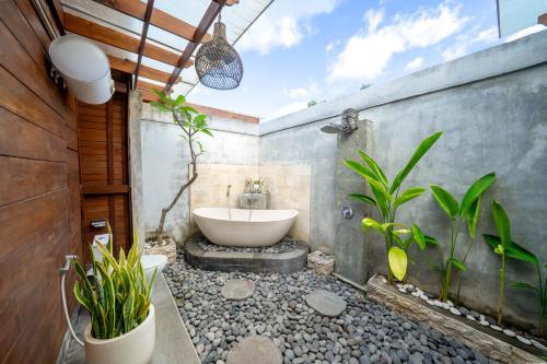 a bathroom with a bath tub and a sink at Innora Jungle Resort And Spa in Nusa Penida