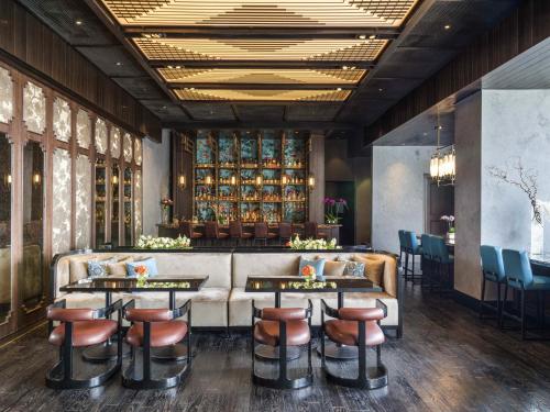 a restaurant with a bar with stools and tables at Swissôtel Jakarta PIK Avenue in Jakarta