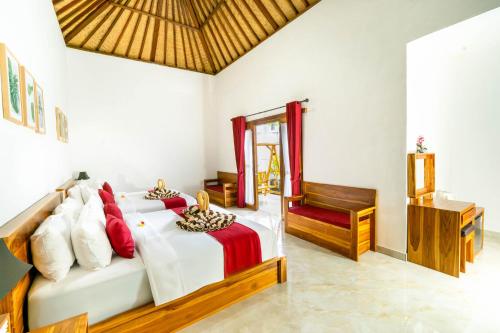 a bedroom with a bed with red and white pillows at Innora Jungle Resort And Spa in Nusa Penida