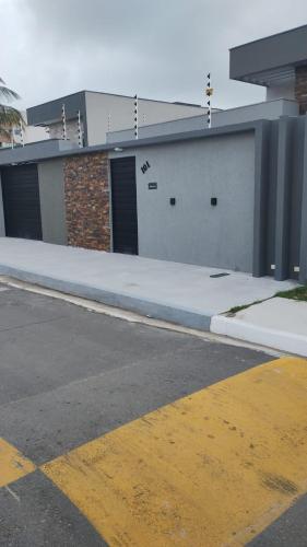 un edificio con due porte da garage e un parcheggio di Casa de Praia, Piscina e Conforto no Frances a Marechal Deodoro