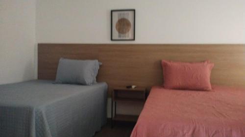 una camera con 2 letti con cuscini rosa e blu di Casa de Praia, Piscina e Conforto no Frances a Marechal Deodoro