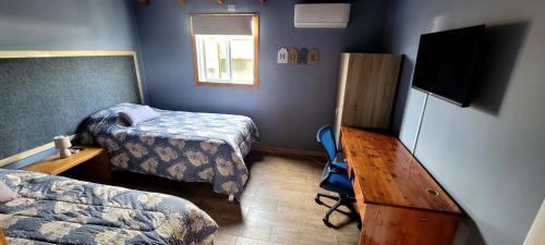 a room with two beds and a television in it at Cabaña ejecutiva in Río Bueno