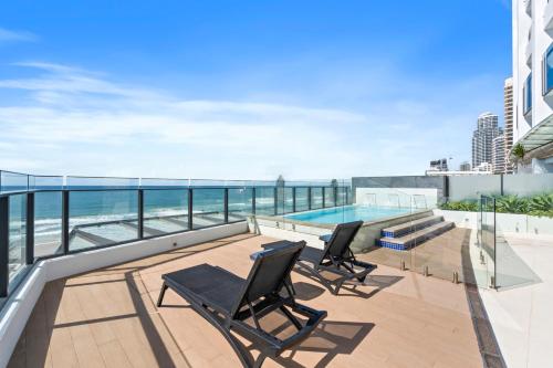 a balcony with two chairs and a swimming pool at Soul Surfers Paradise - Hosted by Gold Coast Luxury Resorts in Gold Coast