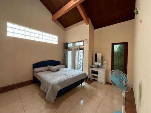 a bedroom with a bed with a fan and a television at Villa Sakinah Ciwidey in Bandung