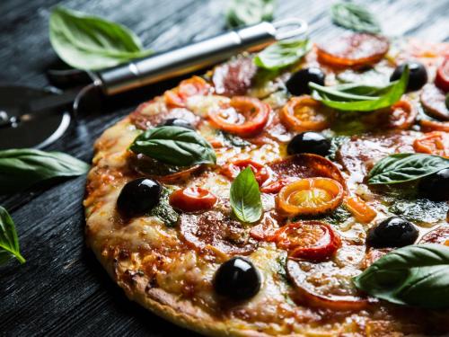 a pizza with tomatoes and basil on a table at Fairmont El San Juan Hotel in San Juan