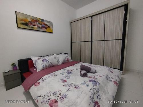 a bedroom with a bed with a floral bedspread at Tamu Homestay in Bemban