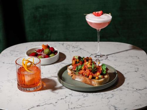 a table with a plate of food and a drink at Fairmont Hotel Macdonald in Edmonton