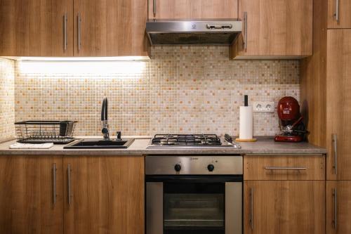 a kitchen with wooden cabinets and a stove top oven at Mátrai Kisház in Mátraszentimre