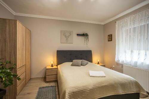 a bedroom with a bed with two lamps on it at Mátrai Kisház in Mátraszentimre