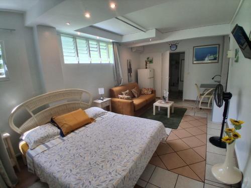 a bedroom with a bed and a living room at Proprizen in Rivière-Salée
