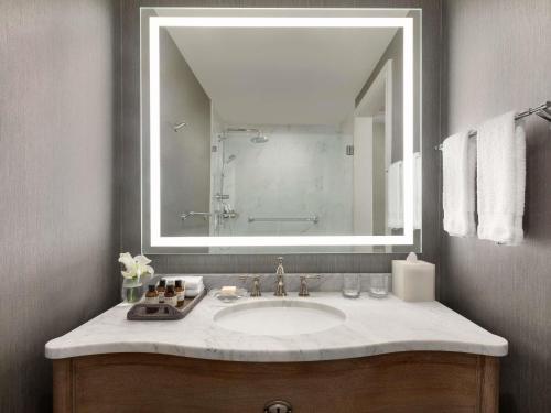 a bathroom with a sink with a large mirror at Fairmont Dallas in Dallas