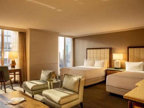 a hotel room with two beds and a chair at Fairmont Dallas in Dallas
