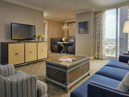 a living room with a couch and a tv at Fairmont Dallas in Dallas