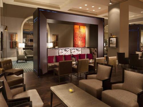 a lobby with a waiting area with chairs and tables at Fairmont Dallas in Dallas