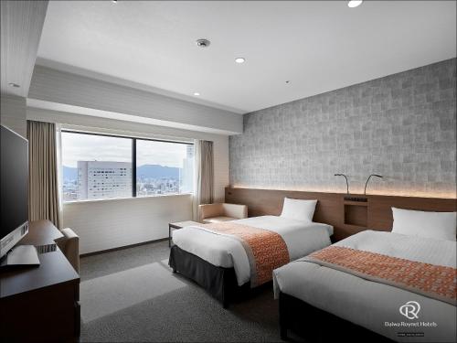 a hotel room with two beds and a window at Daiwa Roynet Hotel Hiroshima-ekimae in Hiroshima