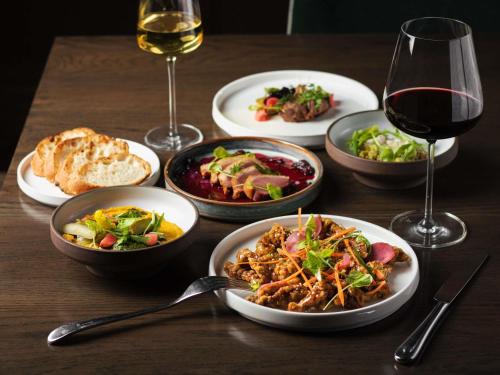 a table with plates of food and a glass of wine at Fairmont Palliser in Calgary