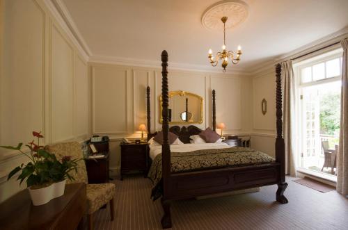 a bedroom with a canopy bed and a chandelier at Chateau La Chaire in Rozel