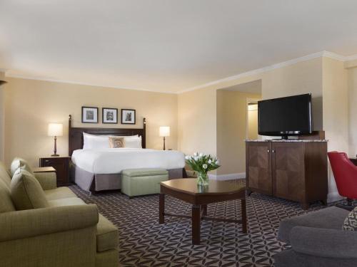 a hotel room with a bed and a flat screen tv at Fairmont Le Manoir Richelieu in La Malbaie
