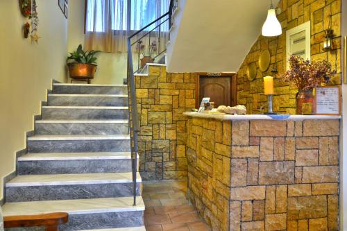 a lobby with stairs and a stone wall at Pension Posidon in Olympia