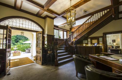 a lobby with a staircase and a bar with chairs at Chateau La Chaire in Rozel