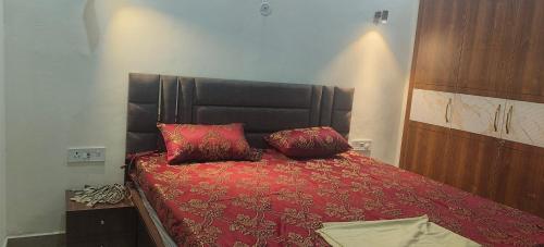 a bedroom with a red bed with two pillows on it at Girivan in Alwar