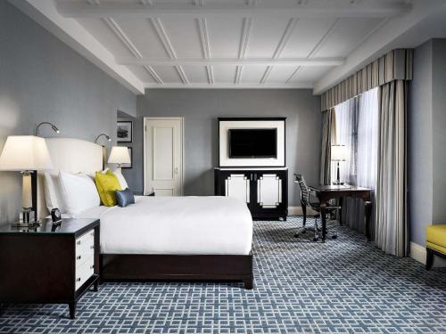 a hotel room with a large bed and a desk at Fairmont Royal York Hotel in Toronto