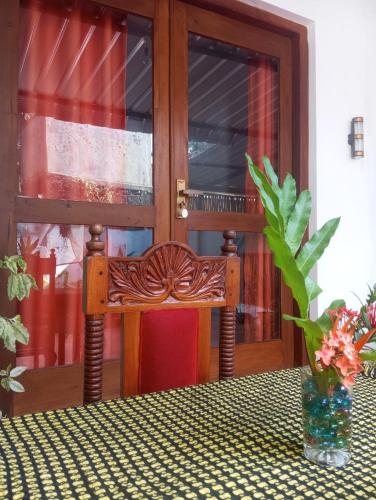 a wooden bench sitting at a table in front of a door at Dishari Tangalle in Tangalle
