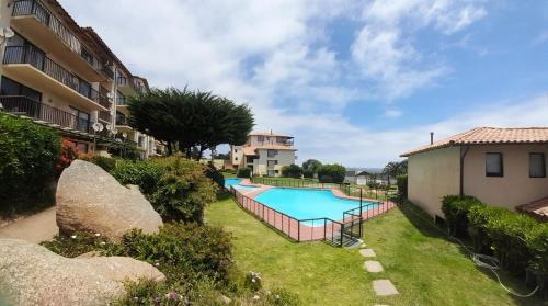 a swimming pool in a yard next to a building at Bella vista al mar y cerca!! in El Quisco