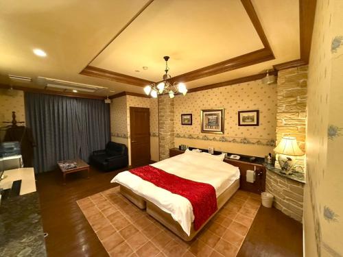 a bedroom with a large bed and a living room at ホテルメイフェア Adult Only 男塾ホテルグループ in Yōkaichi