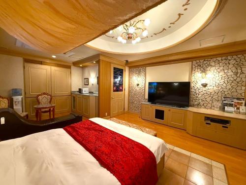 a bedroom with a large bed and a flat screen tv at ホテルメイフェア Adult Only 男塾ホテルグループ in Yōkaichi