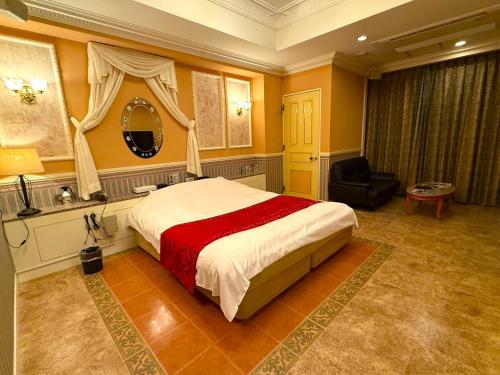 a bedroom with a large bed and a chair at ホテルメイフェア Adult Only 男塾ホテルグループ in Yōkaichi