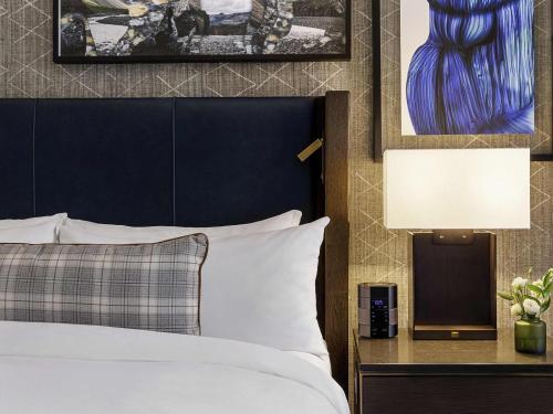 a bedroom with a bed with a blue headboard and a lamp at Fairmont Banff Springs in Banff