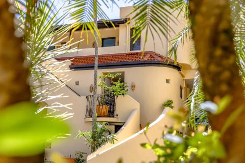 an apartment building with a balcony and palm trees at Villa San Michele (Official) in Port Douglas