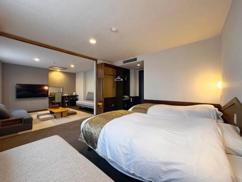 a hotel room with a large bed and a living room at Hotel Cerulean Alpine in Otari