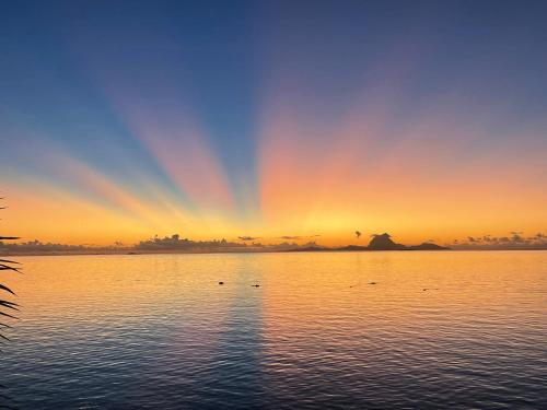 a rainbow in the sky over a large body of water at AHARAU lodge in Tapu' amu