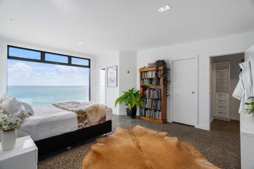 a bedroom with a bed and a large window at Oceanview Oasis - Home & Apartment in Tairua