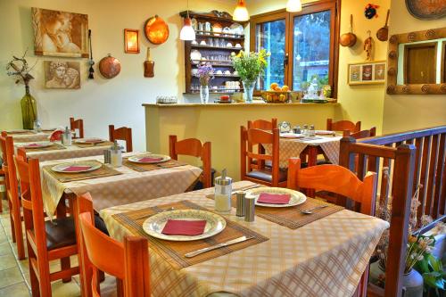 un comedor con mesas y sillas en un restaurante en Pension Posidon, en Olimpia