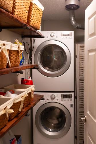 a washer and dryer in a laundry room with baskets at Stylish Private Home 1 mile from Downtown Franklin in Franklin